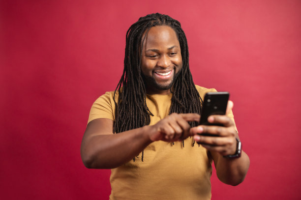 快乐的黑皮肤的人看着手机屏幕图片下载
