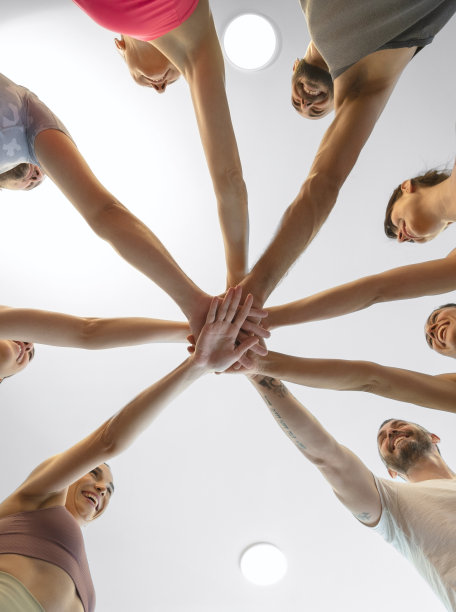 一群朋友在体育馆里把手放在对方的上面图片下载