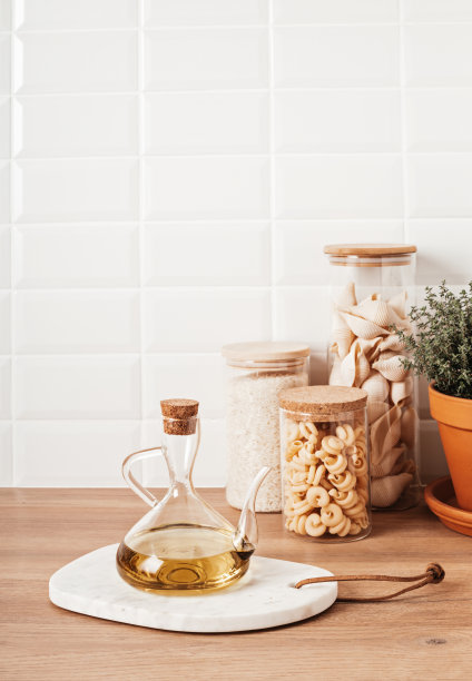 橄榄油，玻璃罐中各种各样的谷物和意大利面，以及木制的厨房用具图片下载