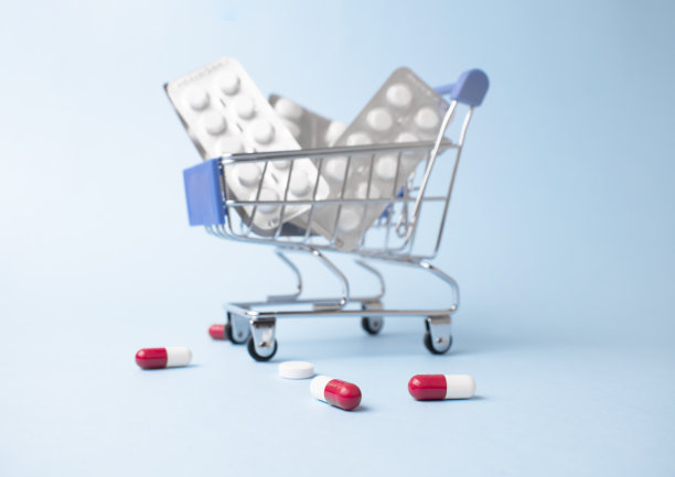 医学概念。各种胶囊，药片和药品在商店手推车在一个蓝色的背景。药的概念。购买和购买药品。图片下载