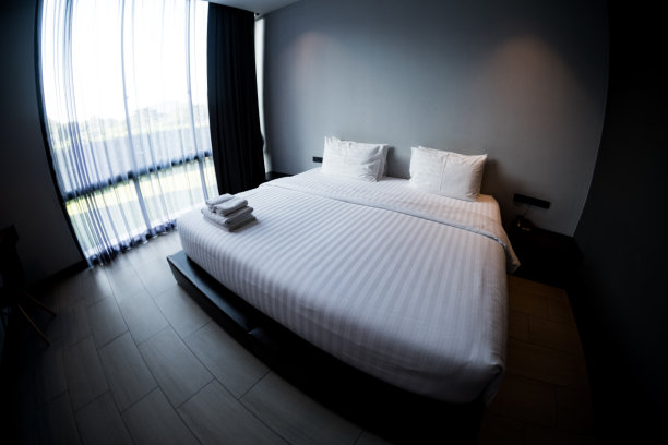 酒店卧室的白色床和枕头。用鱼眼镜头拍照图片下载