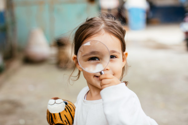 小女孩在玩放大镜图片下载