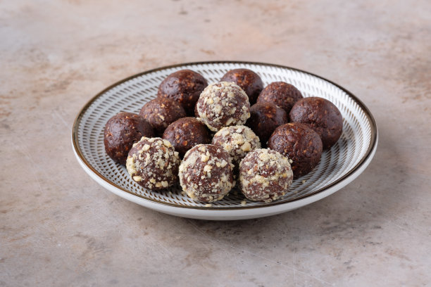 一盘自制的由枣、可可和榛子制成的生巧克力能量球。健康的素食和素食食品。图片下载