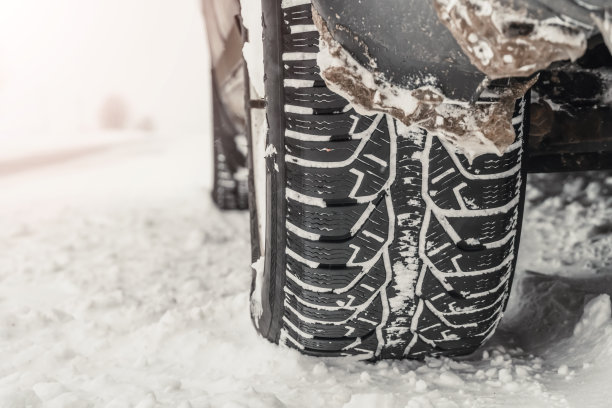 雪地里一辆汽车的后轮的特写。冬天雪地里的轮胎。本空间图片下载