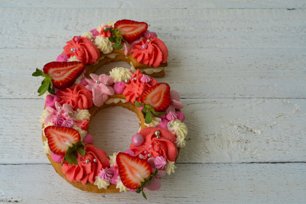 生日蛋糕。草莓的独特现代设计。春天的时间。假期的明信片。漂亮的6号蛋糕，以纯朴的白色木制为背景图片下载