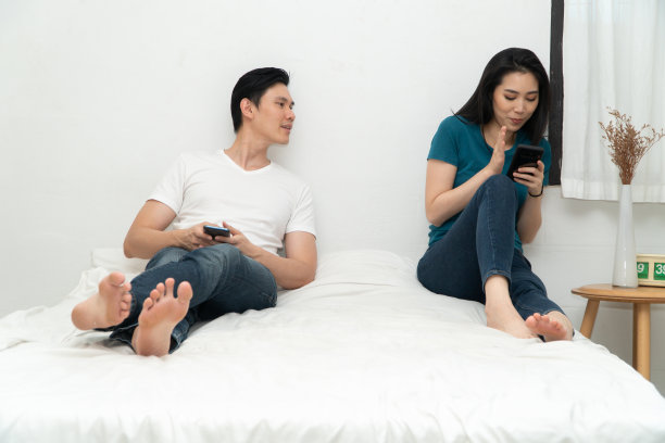 亚洲丈夫对我妻子使用智能手机的异常感到怀疑，他的妻子无视他，一直使用智能手机。关系问题和不忠的概念图片下载