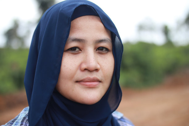 在日光下的户外，在大自然中，快乐的亚洲穆斯林妇女戴着头巾对着镜头微笑图片下载