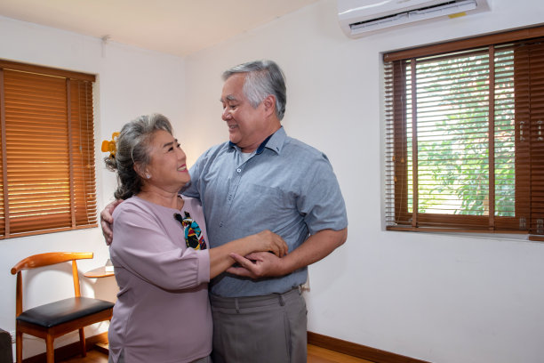 亚洲老夫妇在客厅里一起跳舞。图片下载