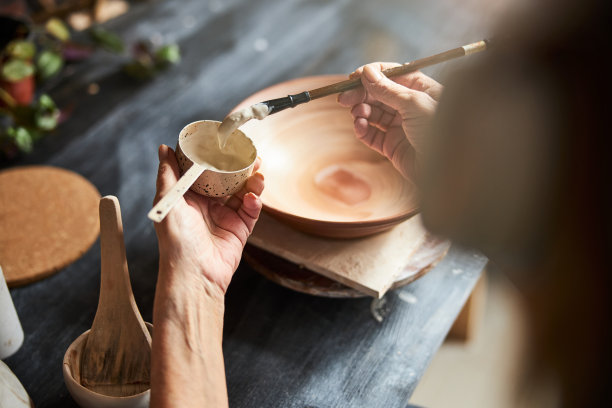 女陶艺家在陶器作坊里画陶器图片下载