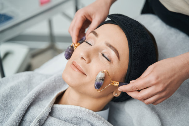 一个闭着眼睛做面部按摩的女人图片下载