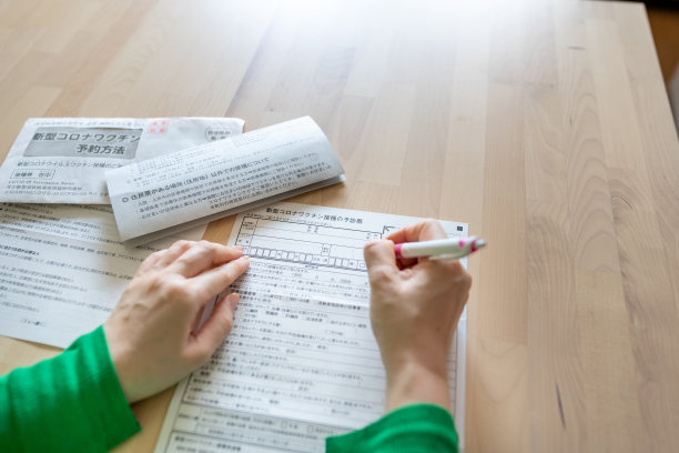 填写COVID-19疫苗接种表格的亚洲女性图片下载