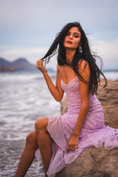 在尼贾尔加塔Cabo de Gata海边的沙滩上，一位身穿粉色布衣的黑发白种人。在西班牙的安达卢西亚图片下载