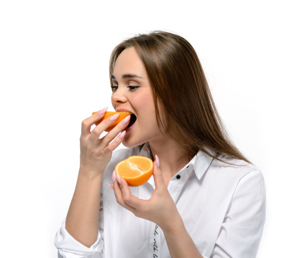 可爱的年轻女子吃橘子。孤立在白色图片下载