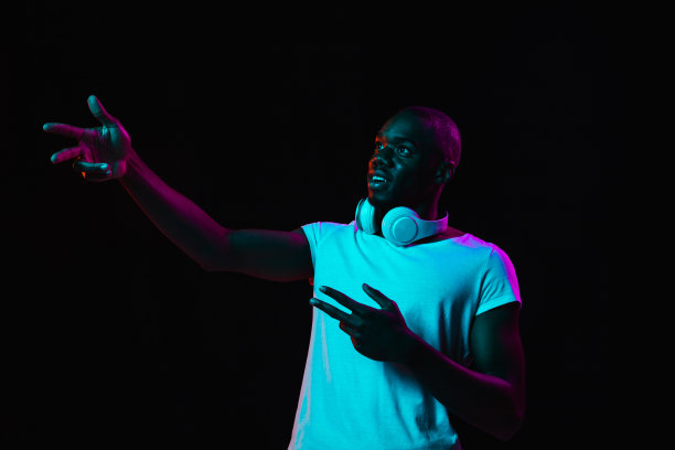 年轻的非裔美国人被孤立在霓虹灯下的黑暗背景下图片下载