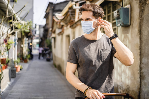 一个戴着外科口罩的英俊男子在小老街图片下载
