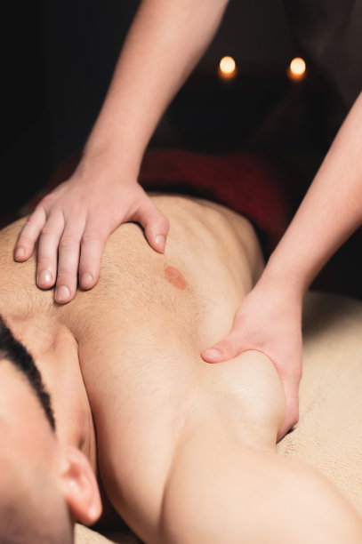 运动按摩。乳房按摩。理疗师给运动员和病人做男性乳房按摩。图片下载