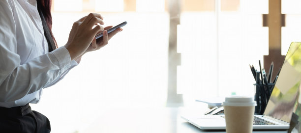 一个女人在家里办公用智能手机的照片图片下载