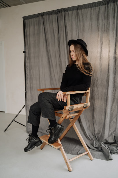 一个女人坐在椅子上，在摄影室摆姿势图片下载