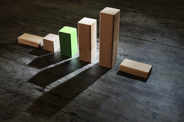 木制玩具积木以图形的形式生长，绿色积木显示上升。带有阴影的低调照片。增长的概念，股票市场的上涨和希望。图片下载