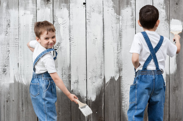 男孩们拿着刷子在旧墙上画画图片下载