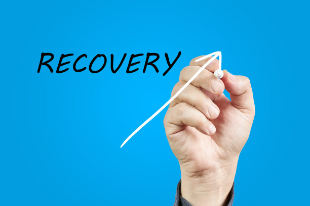 一个男人的手在蓝色背景上的“恢复”旁边画了一个箭头。图片下载