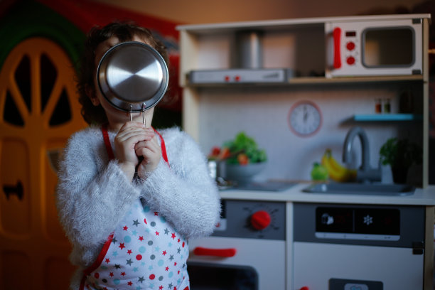 幼小的学前班女孩在玩厨房里的玩具照片图片下载