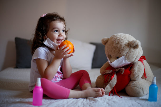 带着医用口罩的小女孩和毛绒熊。儿童疾病的概念，同情、支持和帮助患病儿童的照片图片下载