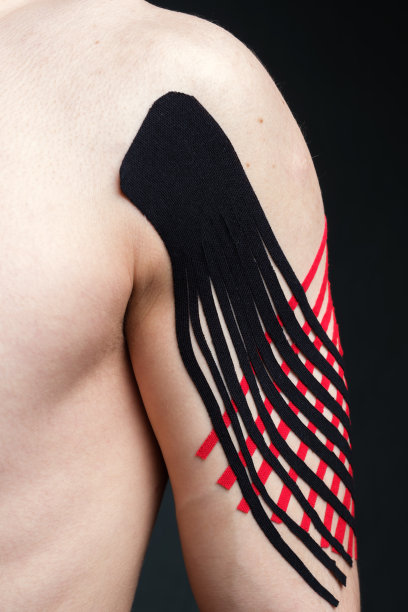 年轻白人男子的二头肌与运动医学胶带应用于减轻疼痛图片下载