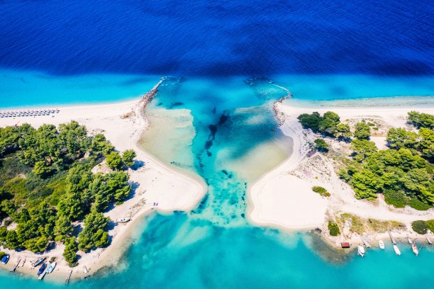 美丽的海滩，金色的沙子和清澈的水。欧洲碧蓝的海岸，碧蓝的海水，金色的沙滩。暑假背景与绿松石海水湾和松树无人机照片视图图片下载