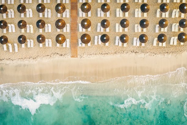 美丽的海滩，金色的沙子和清澈的水。欧洲碧蓝的海岸，碧蓝的海水，金色的沙滩。暑假背景与绿松石海水湾和松树无人机照片视图图片下载