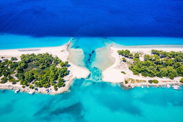 美丽的海滩，金色的沙子和清澈的水。欧洲碧蓝的海岸，碧蓝的海水，金色的沙滩。暑假背景与绿松石海水湾和松树无人机照片视图图片下载