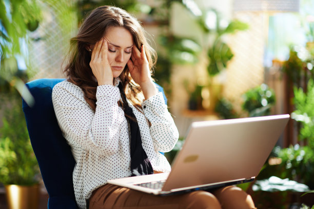 压力时髦的女人在阳光明媚的现代家庭使用笔记本电脑图片下载