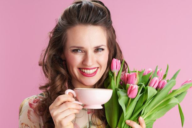 微笑的时尚女人与长波浪黑发在粉红色图片下载