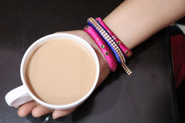 马萨拉奶茶热在华丽的金杯和茶碟在白色的背景图片下载