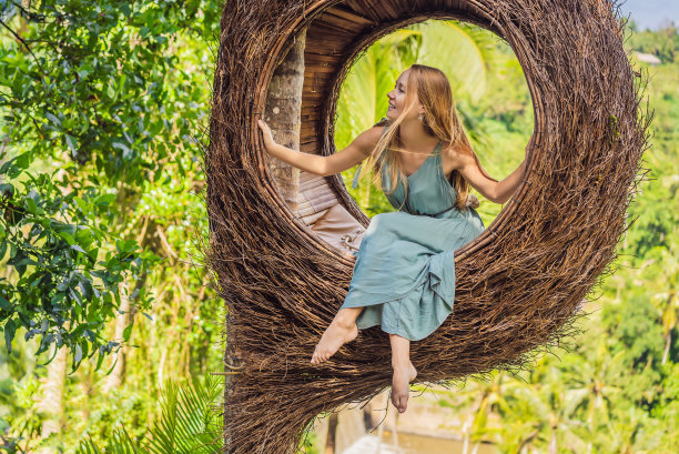 巴厘岛潮流，稻草窝无处不在。年轻的游客享受她的旅行巴厘岛，印度尼西亚。在一座美丽的山上停了下来。图为稻草窝，自然环境。生活方式图片下载