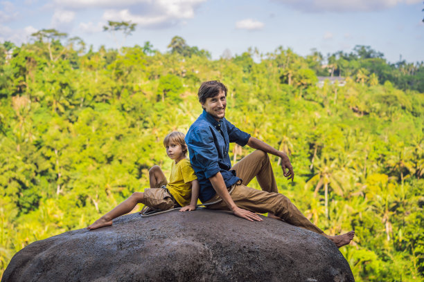 父子游客在一块石头上越过丛林。带着孩子旅行的概念。如何对待孩子。孩子友好的地方图片下载