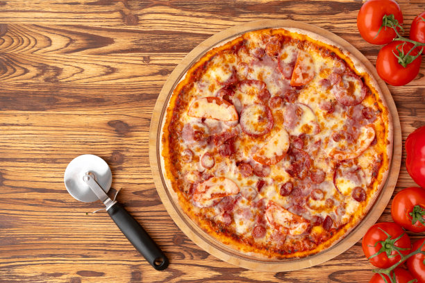 俯视图新鲜烤披萨在木制背景图片下载