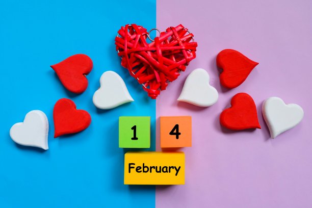 俯视图红色木制手工心符号与软块写在蓝色和紫色的背景2月14日。两色调粉彩背景。情人节的主题。图片下载