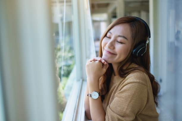 一位年轻美丽的亚洲妇女喜欢用耳机听音乐图片下载