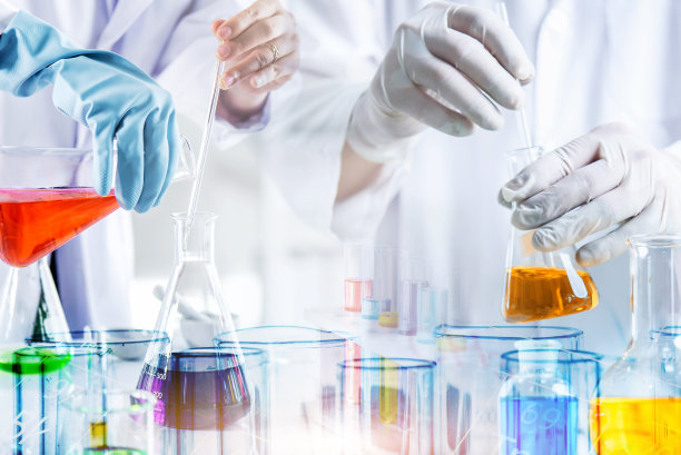 科学家或医生的手检测血液样本与实验室玻璃器皿和试管在化学实验室的背景，科学实验室研究和发展的概念图片下载