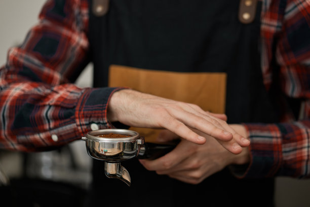 男服务员在围裙为咖啡机托架图片下载