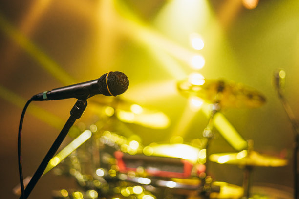 一个麦克风站在音乐会舞台上的照片图片下载