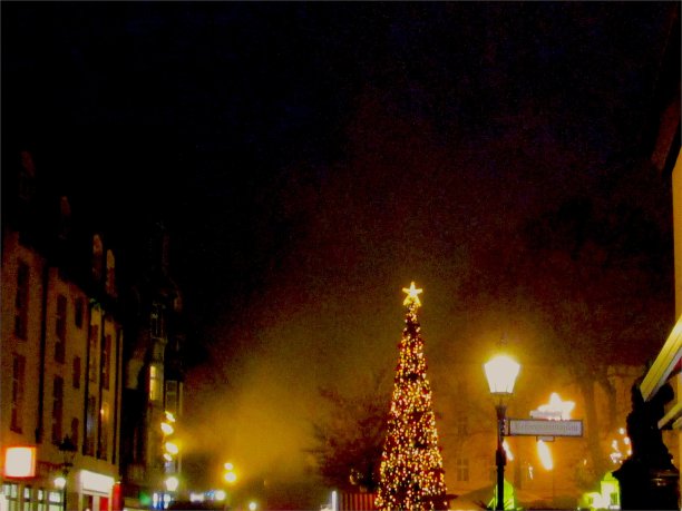 冬夜施潘道老城广场美妙的点亮了圣诞树装饰灯和标志，一个雕塑剪影和周围的老建筑图片下载