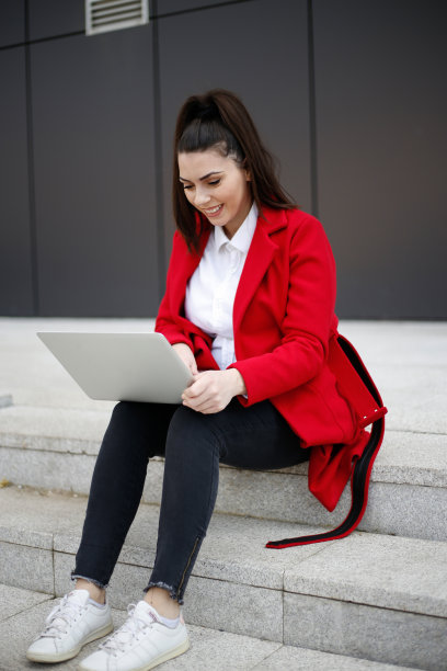 年轻的商业女性在户外使用笔记本电脑。库存图片图片下载