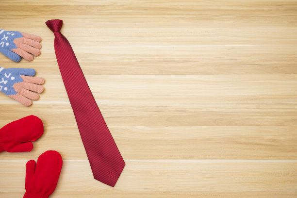 女儿和孩子给父亲红色领带礼物的场景，在左侧木质背景的无商标手套图片下载