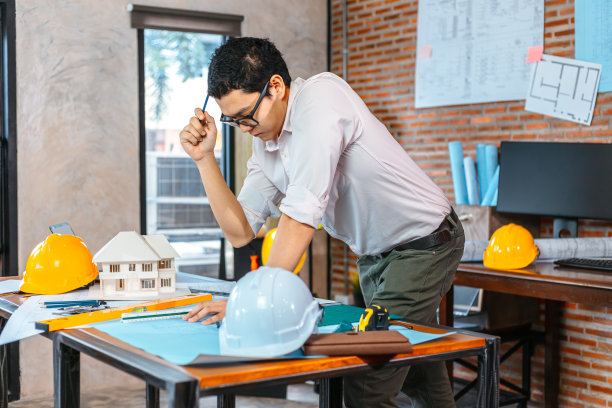 女工程师在房间工地的工作场所阅读图纸。工程师建筑师计划概念。图片下载