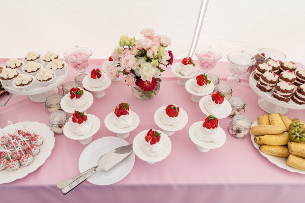 甜蜜的婚礼桌子上的蛋糕和草莓，水果和鲜花。图片下载