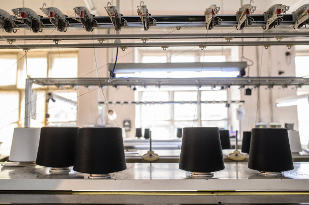 在针织机上黑色的线锥的照片图片下载