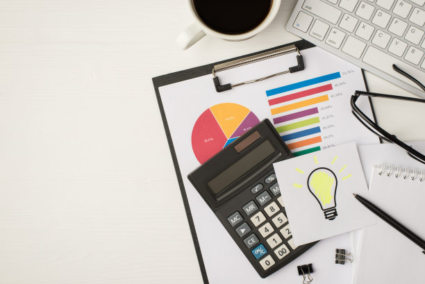 俯视图的照片与键盘眼镜、钢笔、笔记本、咖啡贴纸与灯泡绘图和计算器在饼图上孤立的白色背景与copyspace图片下载