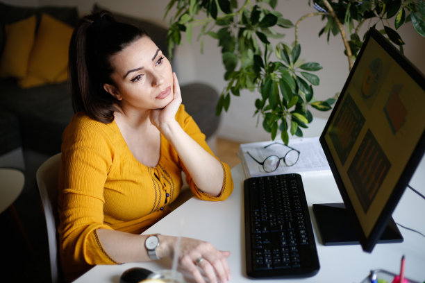 疲惫的女商人在办公室里拿着笔记本电脑。库存图片图片下载